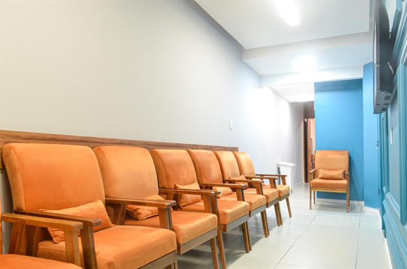 Sala de espera da COE com poltronas e parede azul
